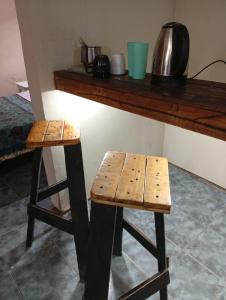 zwei hölzerne Hocker neben einer Theke in der Unterkunft la Cruz 2 in Formosa