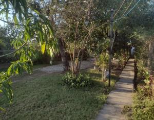 einen Weg durch einen Garten mit Bäumen und Gras in der Unterkunft la Cruz 2 in Formosa