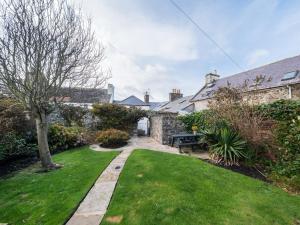 un jardín de una casa con un patio de césped en 3 Bed in Portpatrick 77308, en Portpatrick