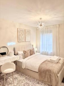 a bedroom with a bed and a desk and a chandelier at Lux Stays - 2BR Leeds City Centre Apartment - Ground Floor with Free Parking in Leeds