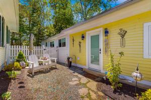 una casa gialla con una staccionata bianca e un patio di Riverbank Manor a Moody