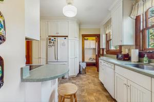 una cucina con mobili bianchi, un lavello e un frigorifero di Riverbank Manor a Moody