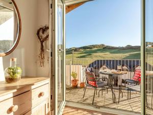 eine Küche mit einem Balkon mit einem Tisch und Stühlen in der Unterkunft 4 Bed in Woolacombe 90224 in Mortehoe + 24 Fotos