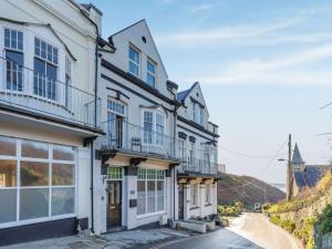 eine Reihe von weißen Häusern mit Balkon auf einer Straße in der Unterkunft 4 Bed in Woolacombe 90224 in Mortehoe