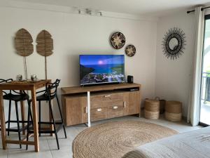 - un salon avec une télévision sur un meuble en bois dans l'établissement Kalista - Studio Luxueux - Anse Marcel, à Saint-Martin