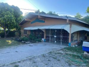 a house with a gate with a dog in it at Livi's Hide-Away! in Spanish Town
