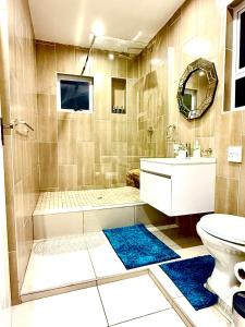 a bathroom with a shower and a sink and a toilet at Umoya Executive Apartment in Mbabane