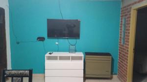 a room with a tv on a blue wall at Sol y luna 7 in Perito Moreno