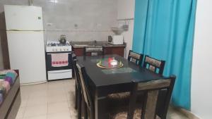 a kitchen with a black table and a white refrigerator at Sol y luna 7 in Perito Moreno