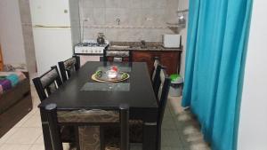 a kitchen with a black table and chairs in a kitchen at Sol y luna 7 in Perito Moreno