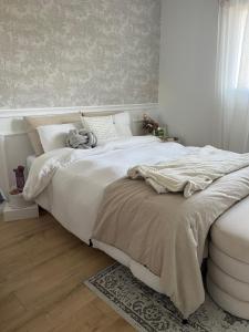 ein Schlafzimmer mit einem großen weißen Bett mit einer Decke in der Unterkunft Location d un étage d une maison in Savigné-lʼÉvêque