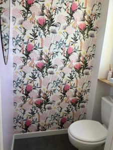 ein Badezimmer mit einem Duschvorhang mit rosa Blumen in der Unterkunft Location d un étage d une maison in Savigné-lʼÉvêque