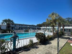 a swimming pool with a fence next to a resort at THE FLORIDIAN INN in Clearwater