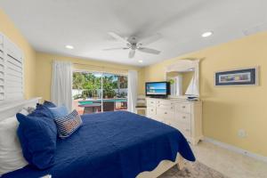 Un dormitorio con una cama azul y un televisor. en Charming Chert, en Isla de Sanibel 65 fotos más