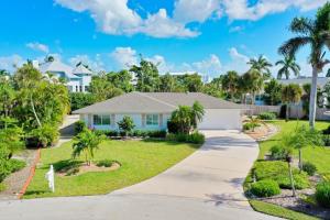 una casa con entrada y palmeras en Charming Chert, en Isla de Sanibel