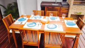 a wooden table with plates and wine glasses on it at Hura Vilas in Itarema