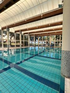 a large swimming pool with blue tiles in a building at Rose Suite in Caesarea