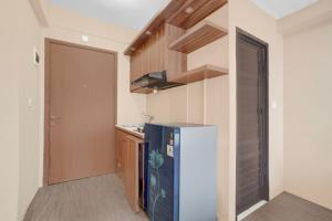 a small kitchen with a refrigerator and a staircase at OYO 94838 Dahoma Tower in Tjikuda Tiga