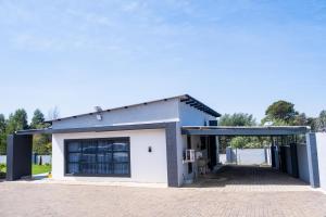 a large white building with a garage at Nkoyoyo Cottage Retreat in Mbabane