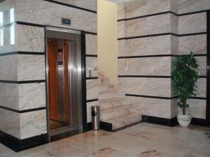 een lobby met een stenen muur met een deur en een plant bij Descanso Termal in Ourense