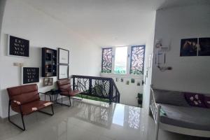 a living room with two chairs and a staircase at Hotel O Rumah Daun Guesthouse Jogja in Demangan