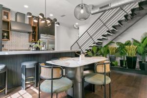 a restaurant with a table and chairs and stairs at New The Artist House - Luxury Hyde Park Home in Tampa