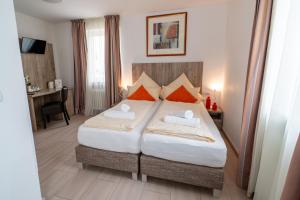 a bedroom with a bed with two towels on it at Hotel Lichtblick Salach in Salach