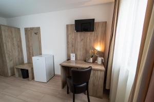 a small room with a desk and a refrigerator at Hotel Lichtblick Salach in Salach