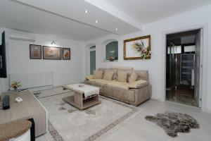 a living room with a couch and a table at Premium Central Apartments - with jacuzzi and private terrace in Râmnicu Vâlcea
