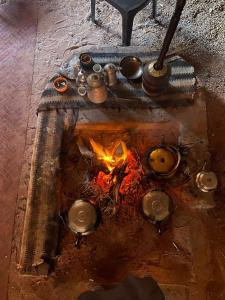 Una chimenea con ollas y sartenes y un fuego en Rum Travel with Mohammad, en Wadi Rum