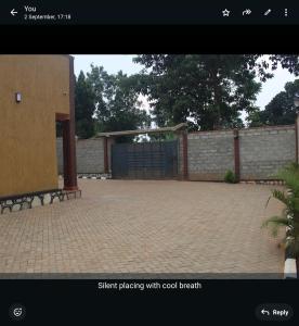 a picture of a driveway with a gate and a fence at Lexus Guest House, Kasangati in Kampala