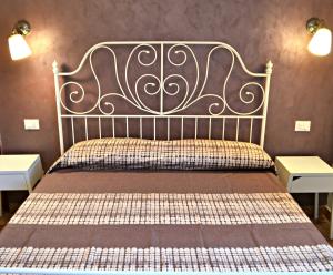 a bed with a metal headboard and two tables at Key of Venice Guest House in Venice