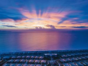 - une vue aérienne sur la plage au coucher du soleil dans l'établissement Mövenpick Resort Cam Ranh, à Cam Ranh