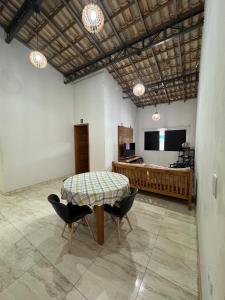 a room with a table and chairs and a television at Chácara Conquistando II in Jarinu