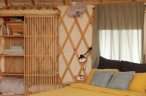 a bedroom with a bed and a book shelf at היורט על הגג - צוקים in Zuqim