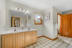 ein Badezimmer mit Waschbecken und Spiegel in der Unterkunft 26 Old Carriage Drive Harwich - The Carriage House in East Harwich + 40 Fotos