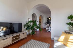 Una sala de estar con un sofá y un televisor. en Appartamento Aurora, immerso nella natura e vicino a Firenze, en Moriano