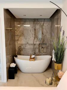 a bath tub in a bathroom with a marble wall at Rose Suite in Caesarea