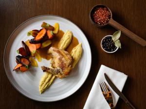 a plate of food with chicken and vegetables on a table at Mövenpick Hotel Lausanne in Lausanne