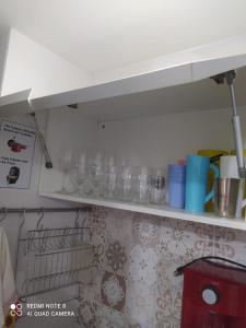 a shelf in a kitchen with glasses on it at Israel Flat 413 Tambau in Tambaú