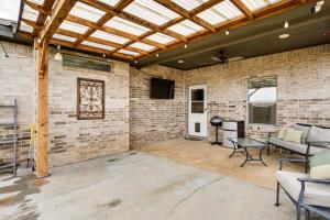 a patio with a brick wall and a wooden ceiling at 11 Mi to Texas Tech University Cozy Family Home! in Wolfforth