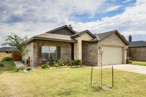 a house with a garage in a yard at 11 Mi to Texas Tech University Cozy Family Home! in Wolfforth