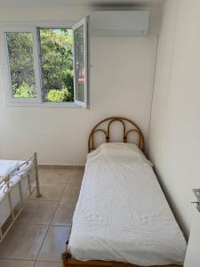 a bed in a room with two windows at Rayon des îles bien désiré in Saint-François