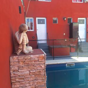 a statue of a person sitting on top of a wall at HOSPEDAJE DODERA in Gualeguaychú