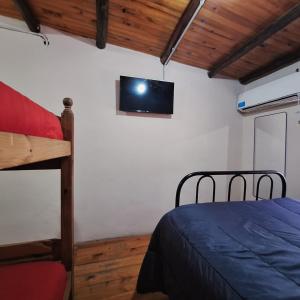 a bedroom with a bed and a tv on the wall at HOSPEDAJE DODERA in Gualeguaychú