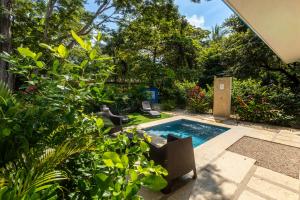 a swimming pool in a garden with plants at Casa Blue Monkey - Playa Conchal in Brasilito