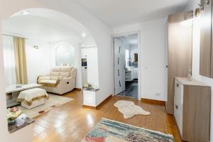 a living room with a chair and a table at Premium Central Apartments - with jacuzzi and private terrace in Râmnicu Vâlcea