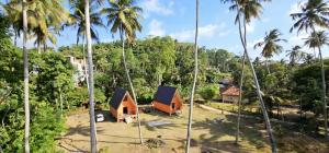 a house in the middle of a forest with palm trees at Beach Cabanas Hiriketiya in Hiriketiya +15 photos