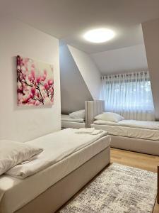 a bedroom with two beds and a painting on the wall at Motel Za Miedzą in Bralin +126 photos