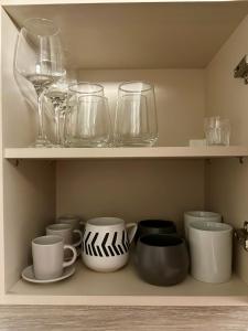 a shelf filled with glasses and plates and bowls at Adrianas Central Stay in Patra +8 photos